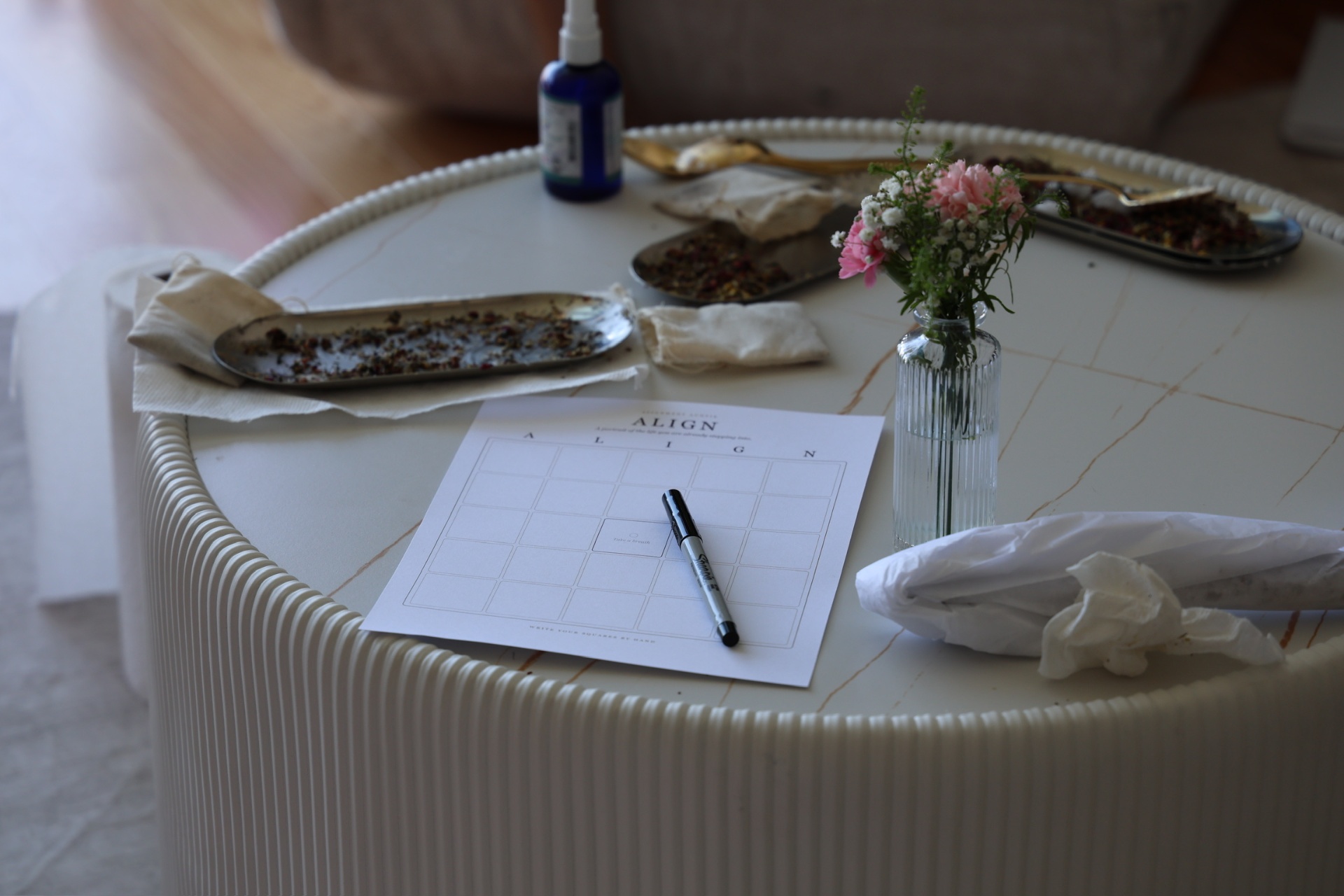A hand-drawn ALIGN board resting on a workshop table beside dried herbs and a bud vase